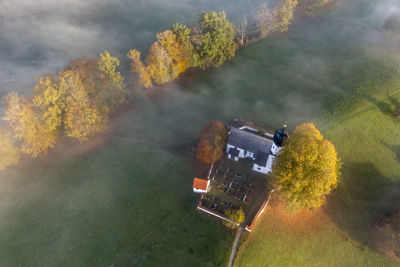 Germany, bavaria, bad heilbrunn, aerial view of church of visitation of virgin mary at foggy autumn dawn