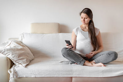 Young woman using mobile phone at home