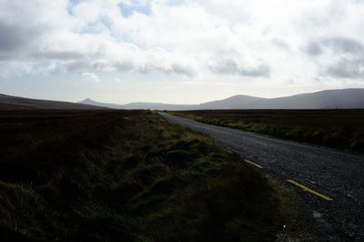 Road by landscape against sky