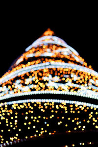 Close-up of illuminated lighting equipment against black background