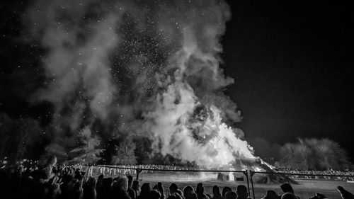 Panoramic view of crowd at concert against sky at night