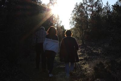 Rear view of people walking in forest
