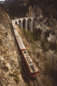 Train by landwasser viaduct against mountains