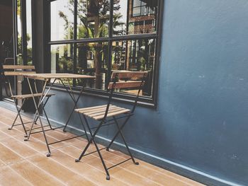 Empty chairs and table against building