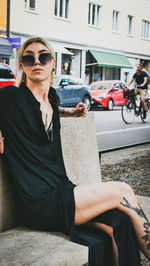 Young woman wearing sunglasses sitting in bus