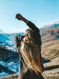 Woman standing in snow covered mountain against sky