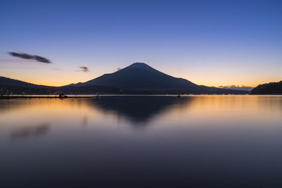 Scenic view of lake and mountain against sky during sunset