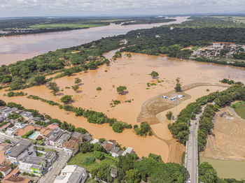 River flooding due to rain causes large mud next to a dam that prevents the rivers from meeting 