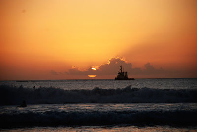 Scenic view of sea against orange sky