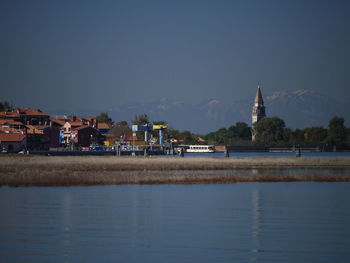 Lake by buildings against sky in city