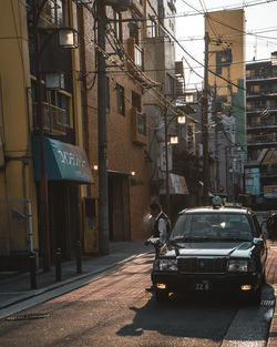 Cars on street by buildings in city