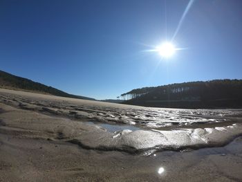 Scenic view of land against clear sky during sunny day