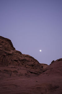 Rock formations against clear sky in wadi rum at dusk