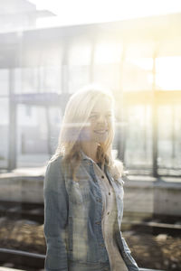 Young woman standing seen through window