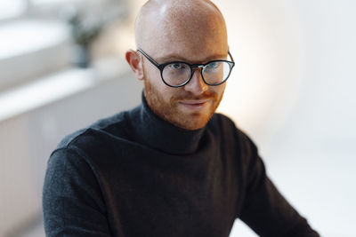 Confident businessman wearing eyeglasses sitting in office