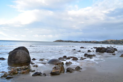Rocks on beach against sky