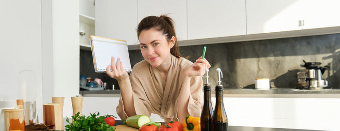 Portrait of young woman preparing food at home