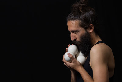 Man holding coffee cup against black background