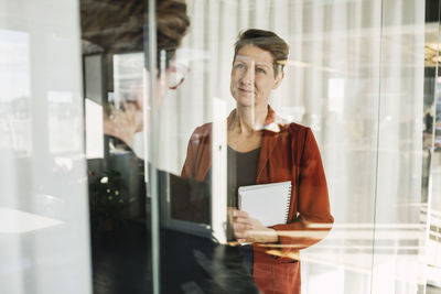Mature businesswoman looking at colleague in office