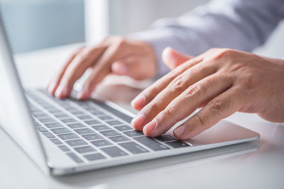 Midsection of man using laptop on table