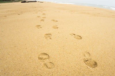 Close-up of footprints on sand at beach