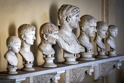 Statues on table against wall