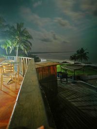 Chairs and table by swimming pool against sky