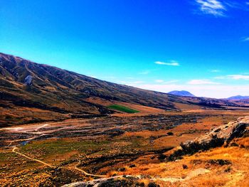 Scenic view of mountains against blue sky