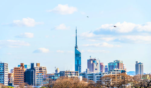 View of buildings in city against cloudy sky