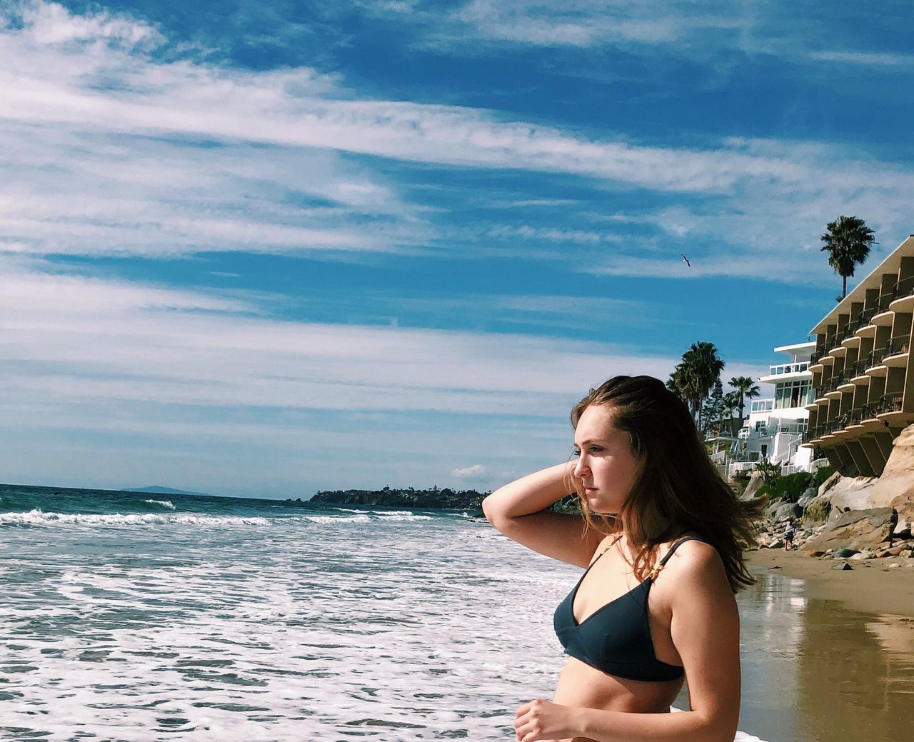 BEAUTIFUL YOUNG WOMAN ON BEACH AGAINST SKY DURING SUNSET