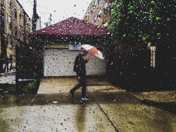 Man walking on wet road during rainy season