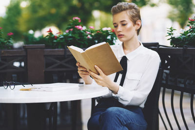 Young woman sitting on chair at table