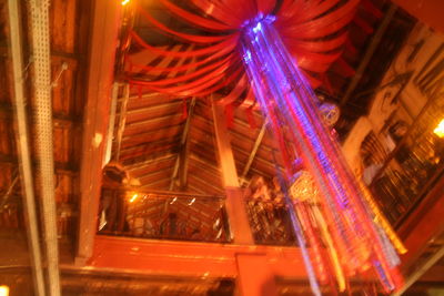 Low angle view of illuminated carousel against sky at night