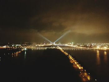 Illuminated cityscape against sky at night