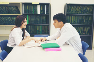 University students studying at table in library