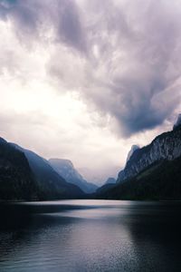 Scenic view of lake by mountains against sky