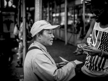 Portrait of man holding ice cream standing outdoors