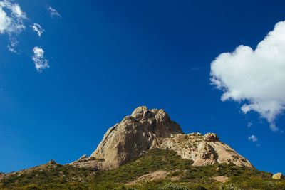 Low angle view of rocks against blue sky