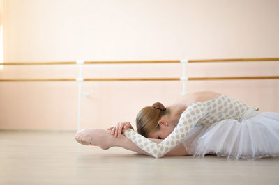 Full length of woman lying on floor at home