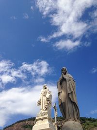 Low angle view of virgin mary statue against sky