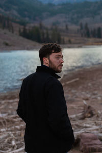 Side view of young man looking at sea