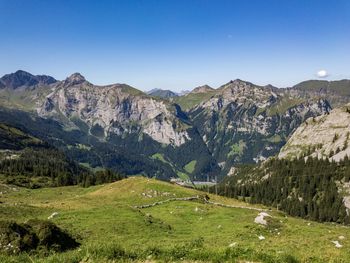 Scenic view of landscape and mountains against clear sky