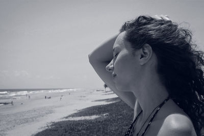 Close-up of woman face at beach against sky