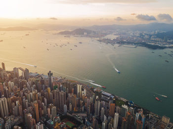 Aerial view of modern buildings in city against cloudy sky