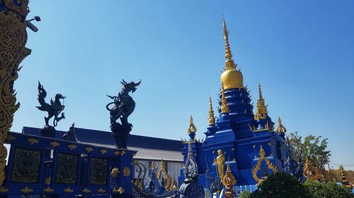 Low angle view of statue of building against blue sky