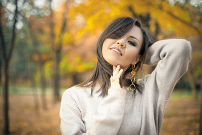 Young woman standing against trees