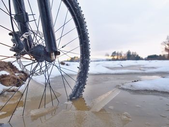 Bike drowned in muddy pool within winter trip. broken pieces of ice around freeze terain tyre,