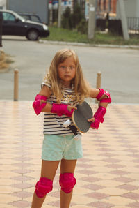 Girl in pink knee pads with skateboard 