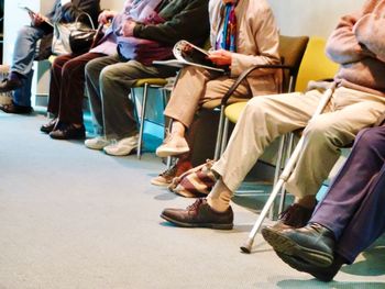 Low section of people sitting on chair