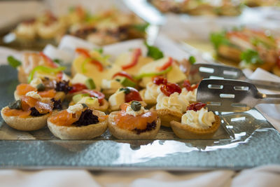 Close-up of food served on tray with serving tongs